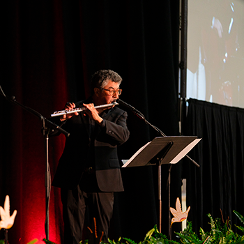 Enrique Rios-Ellis plays the flute during the Investiture.