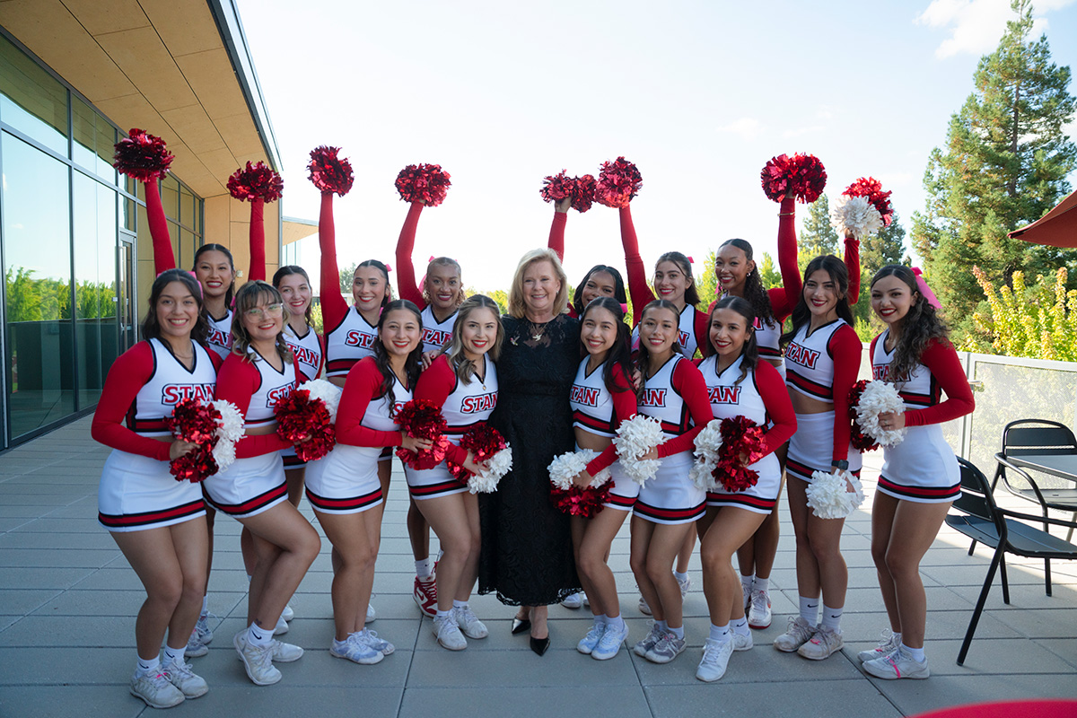 President Britt Rios-Ellis and members of Stan State's cheer squad.