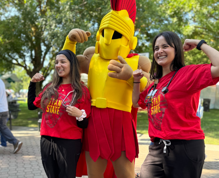 Two students pose for a picture with Titus the Warrior