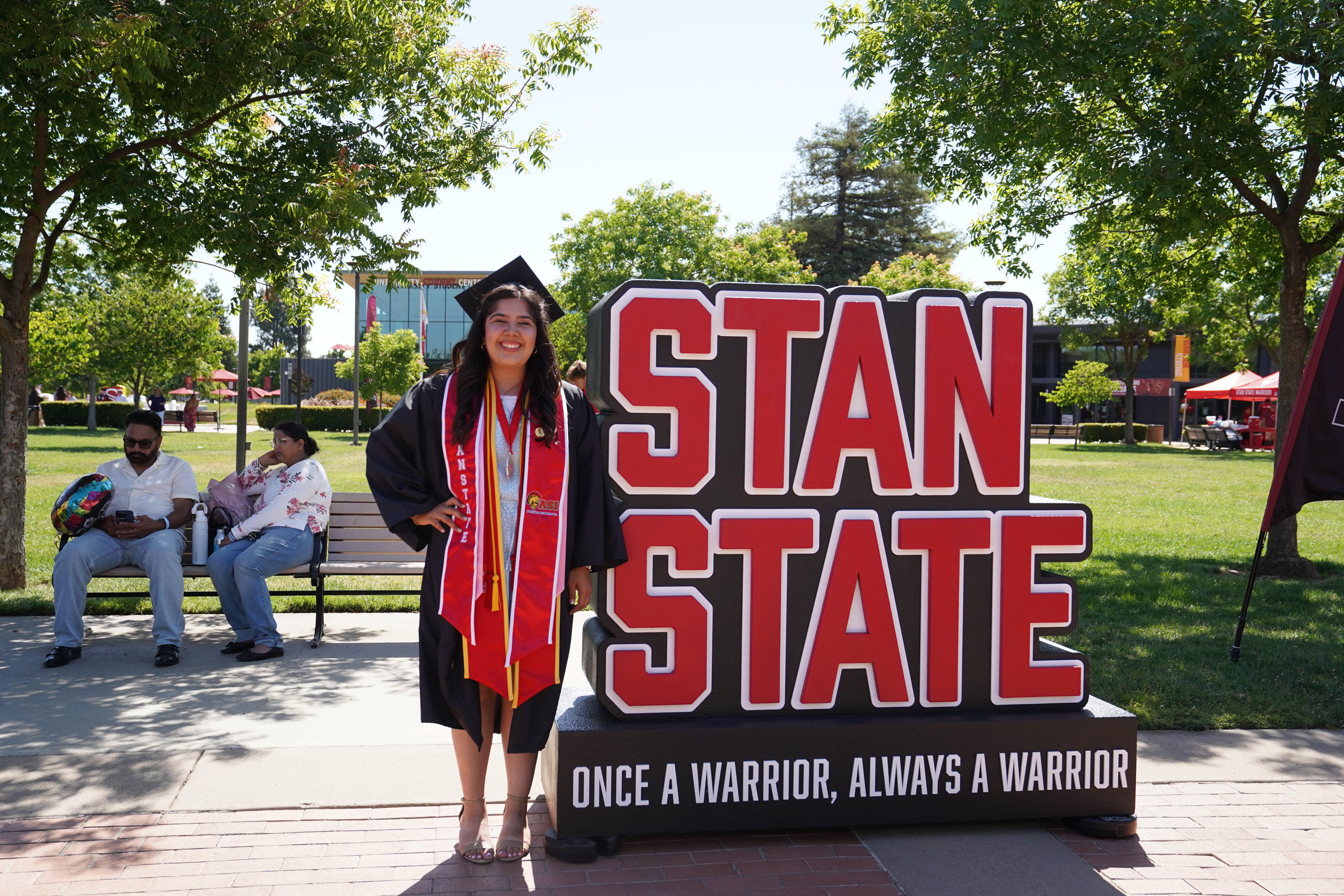 Graduating student posing next to Stan State sign