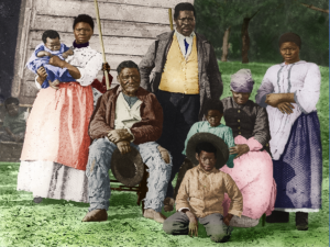 Multiple generations of a family of contrabands posed outside a cabin on the former plantation.