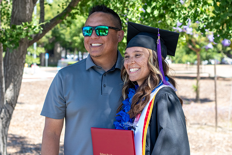 Stan State grad at commencement with family