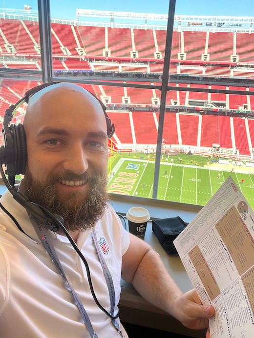 Steven Flowers holding up a statistics sheet in the press box of Levi's Stadium.