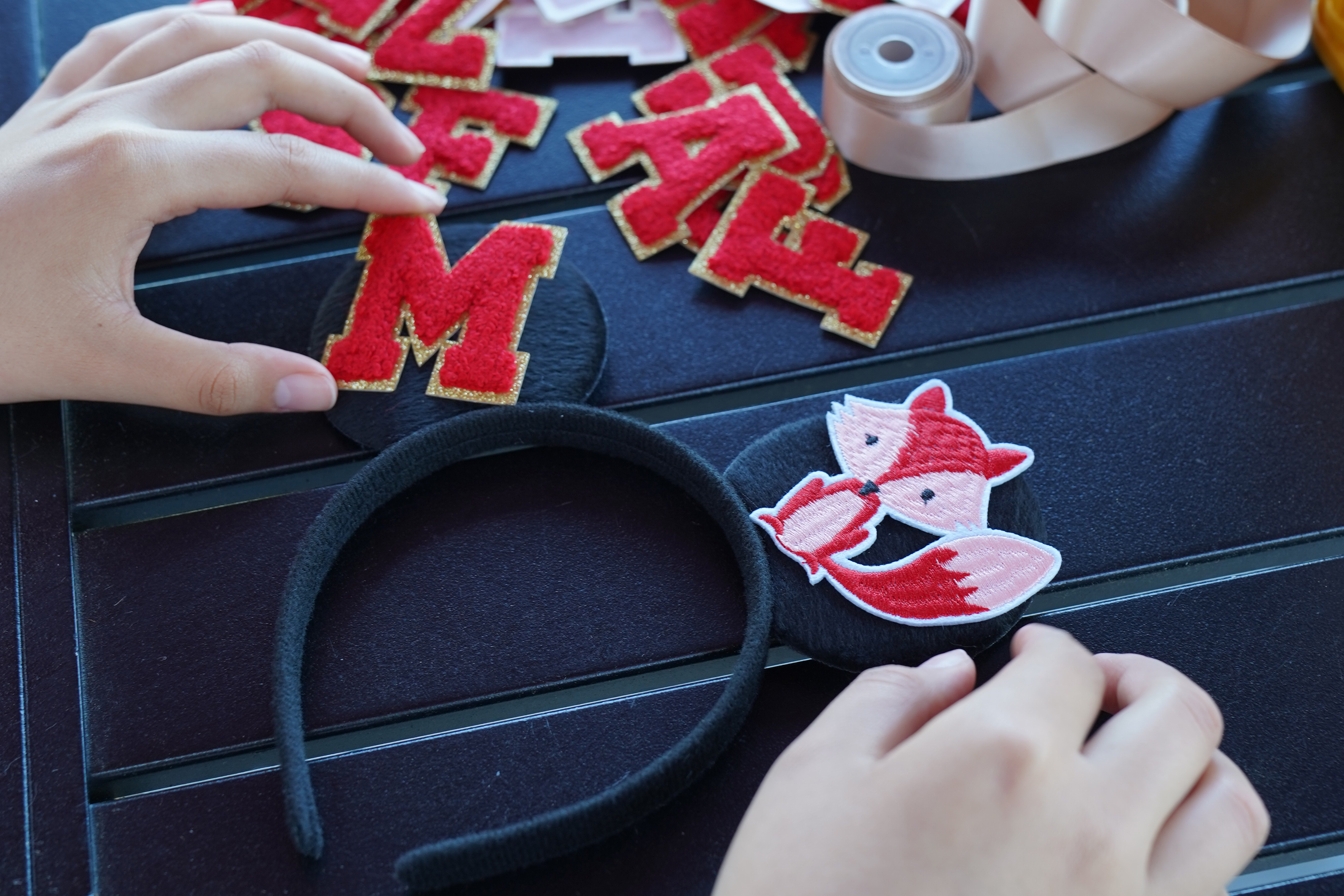 Decorated Mickey-like ears with a red letter M and red fox