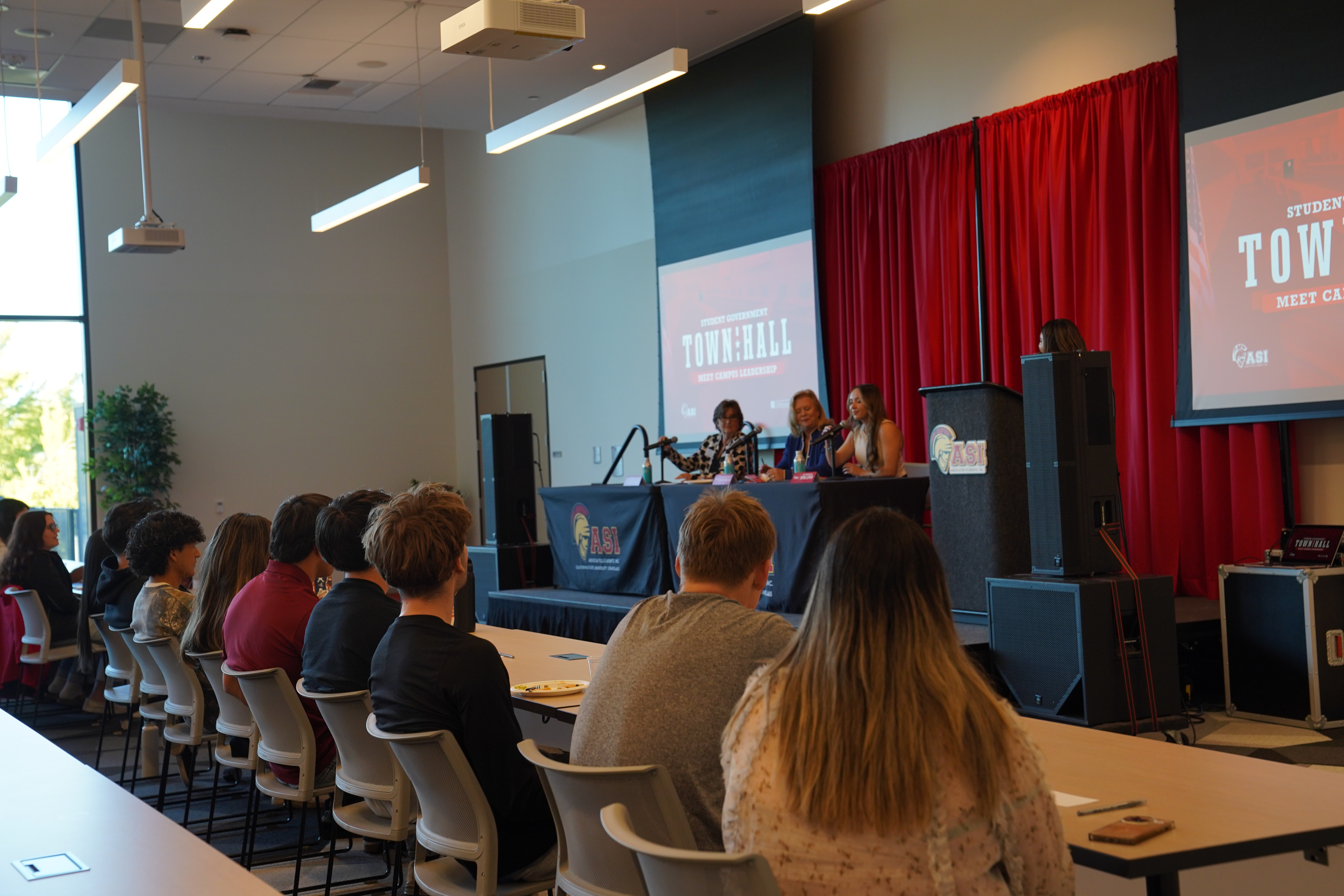 Many students sitting and listening to a presenter during an ASI Student Government Town Hall