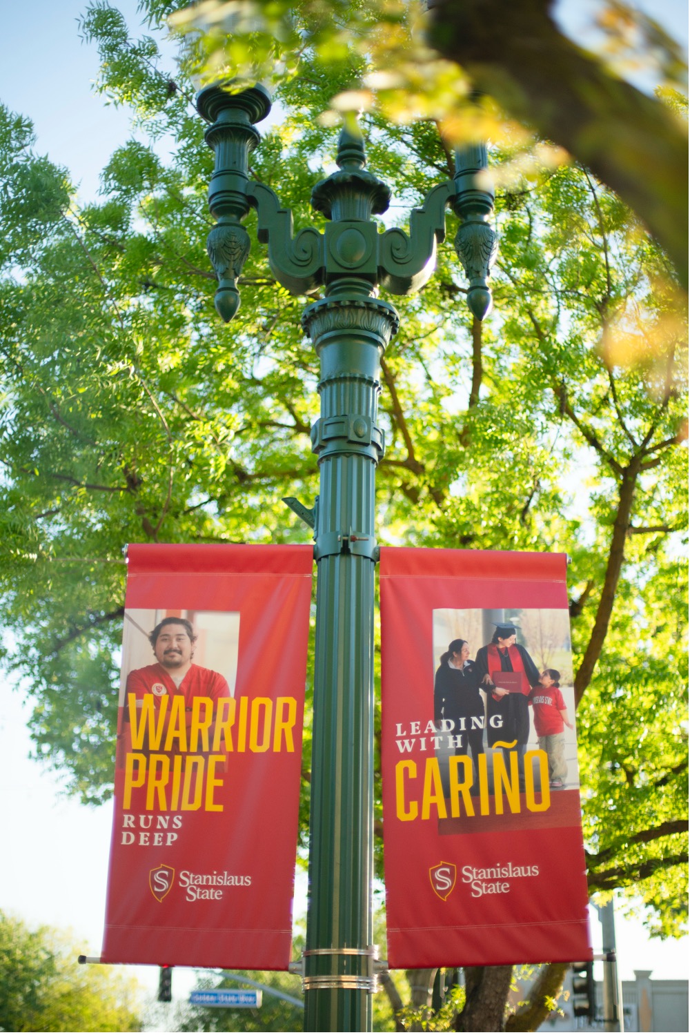 Two Stan State banners hung up on a light post