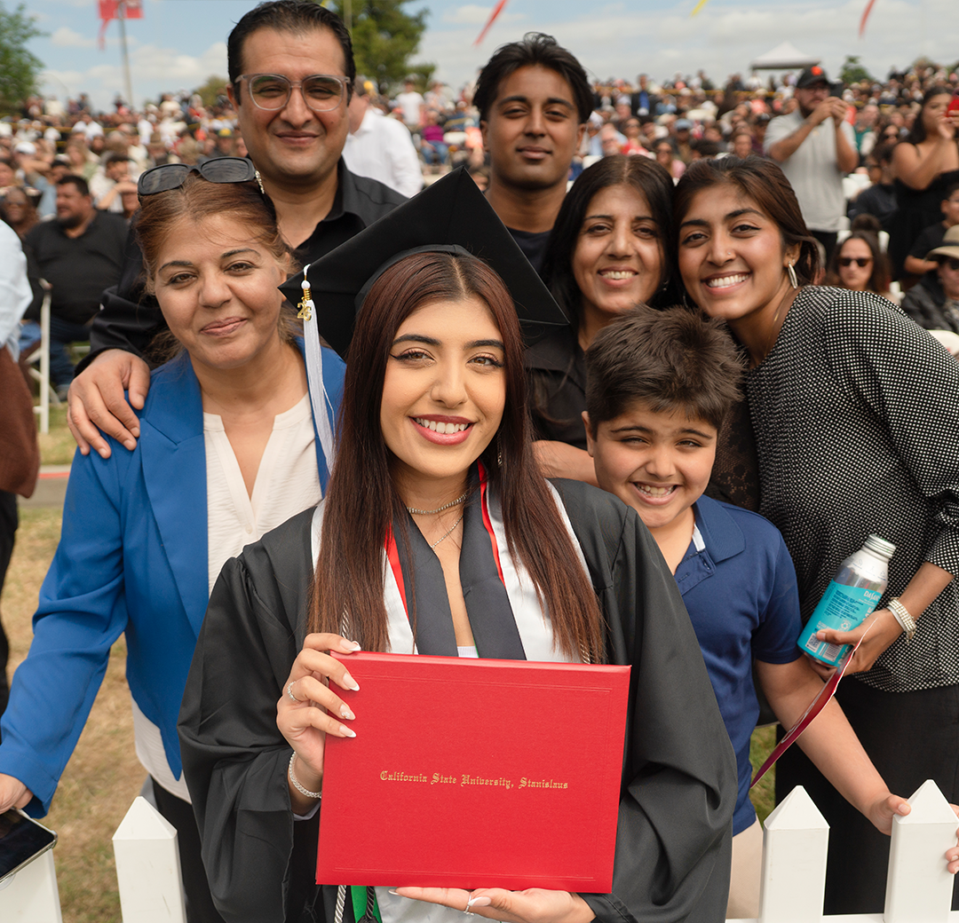 Graduating student poses with her family for a picture.