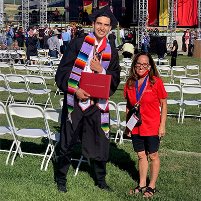 Janice Herring poses with a student at a 2021 Commencement ceremony.