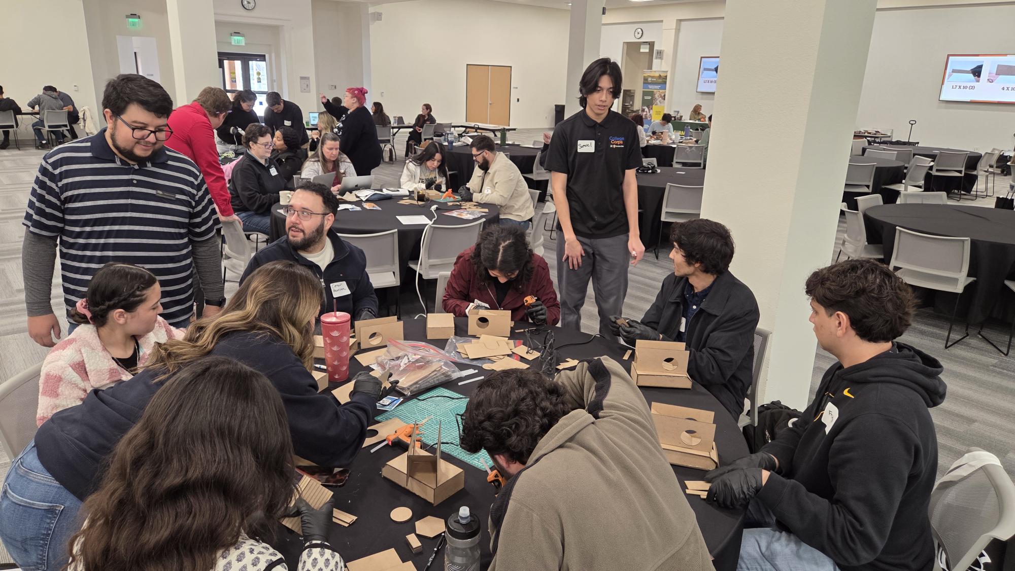 Group of students at a table during a Fab Lab workshop at the 2026 STEAM Symposium.