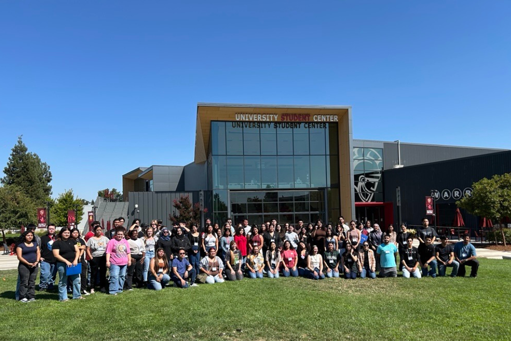 cohort 4 is seen huddled in a group picture by the student center lawn