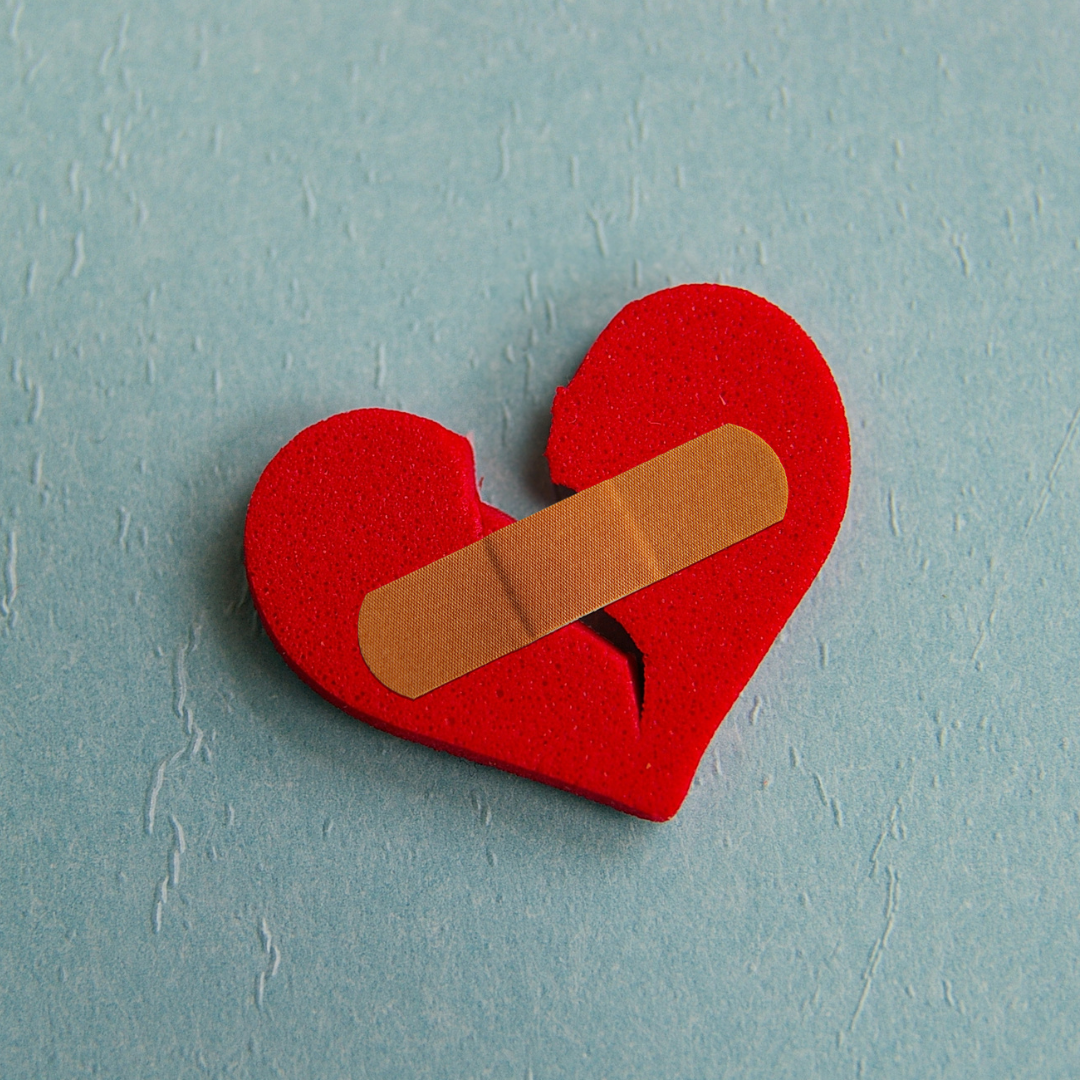 Broken heart with a bandage on it.