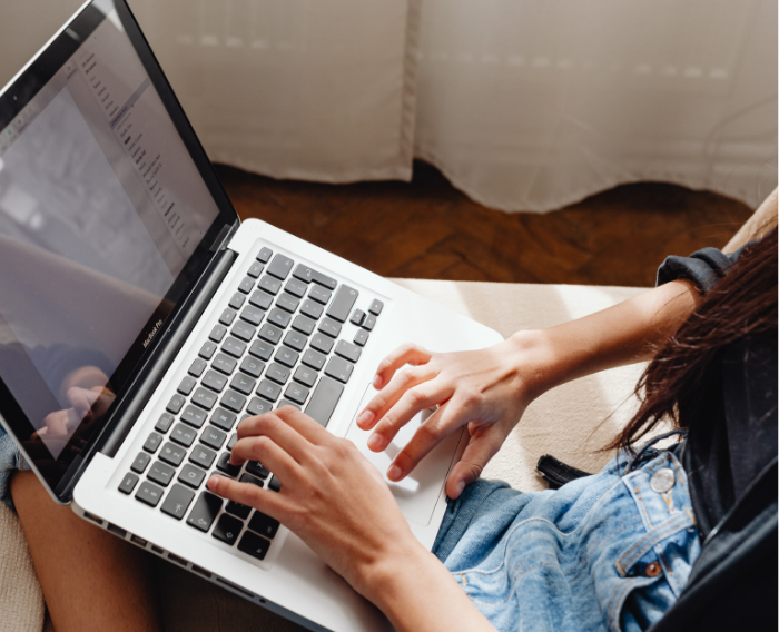 Student typing email on laptop. 