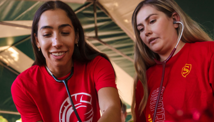 Stan State students using stethoscopes during a health outreach activity. 