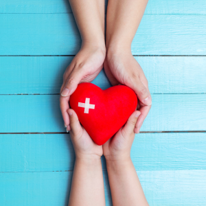 Two sets of hands holding a heart