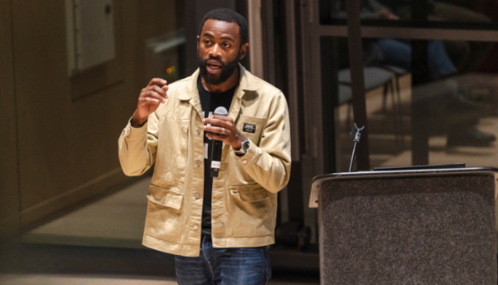 A presenter is seen on stage