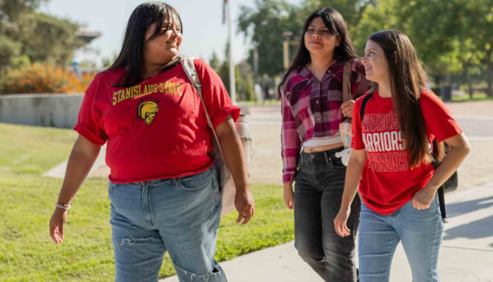 Three students walking together on campus 