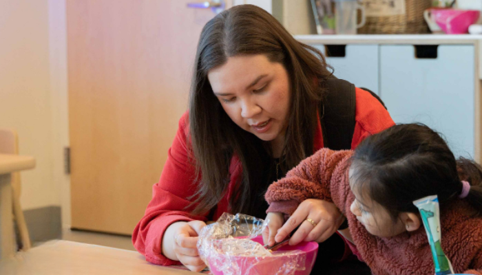 Stan State student is seen helping a child with a craft activity
