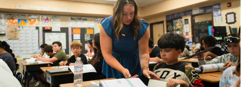 Teacher is seen helping a student in an elementary classroom