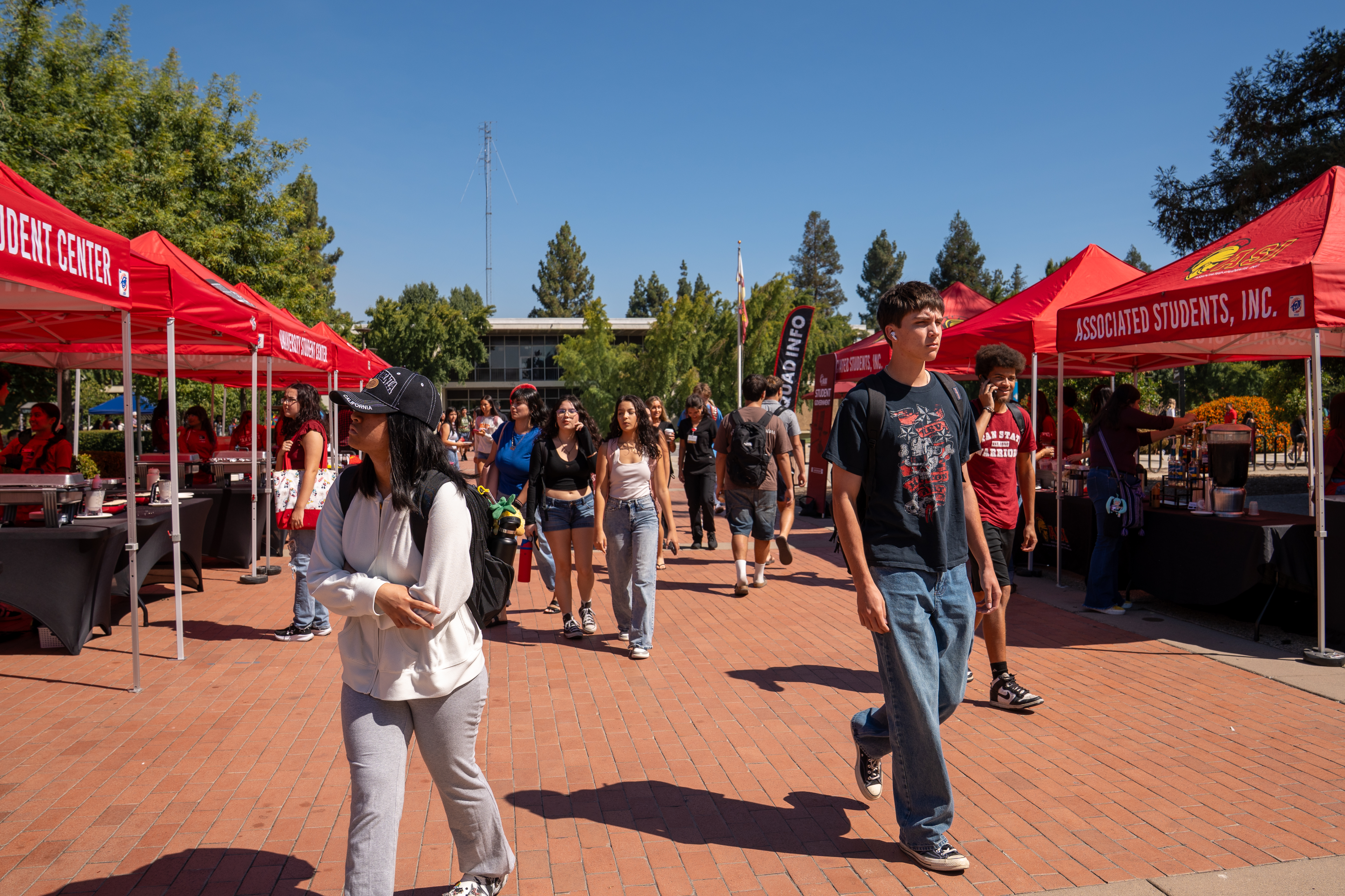 Quad with red canopies and students walking around