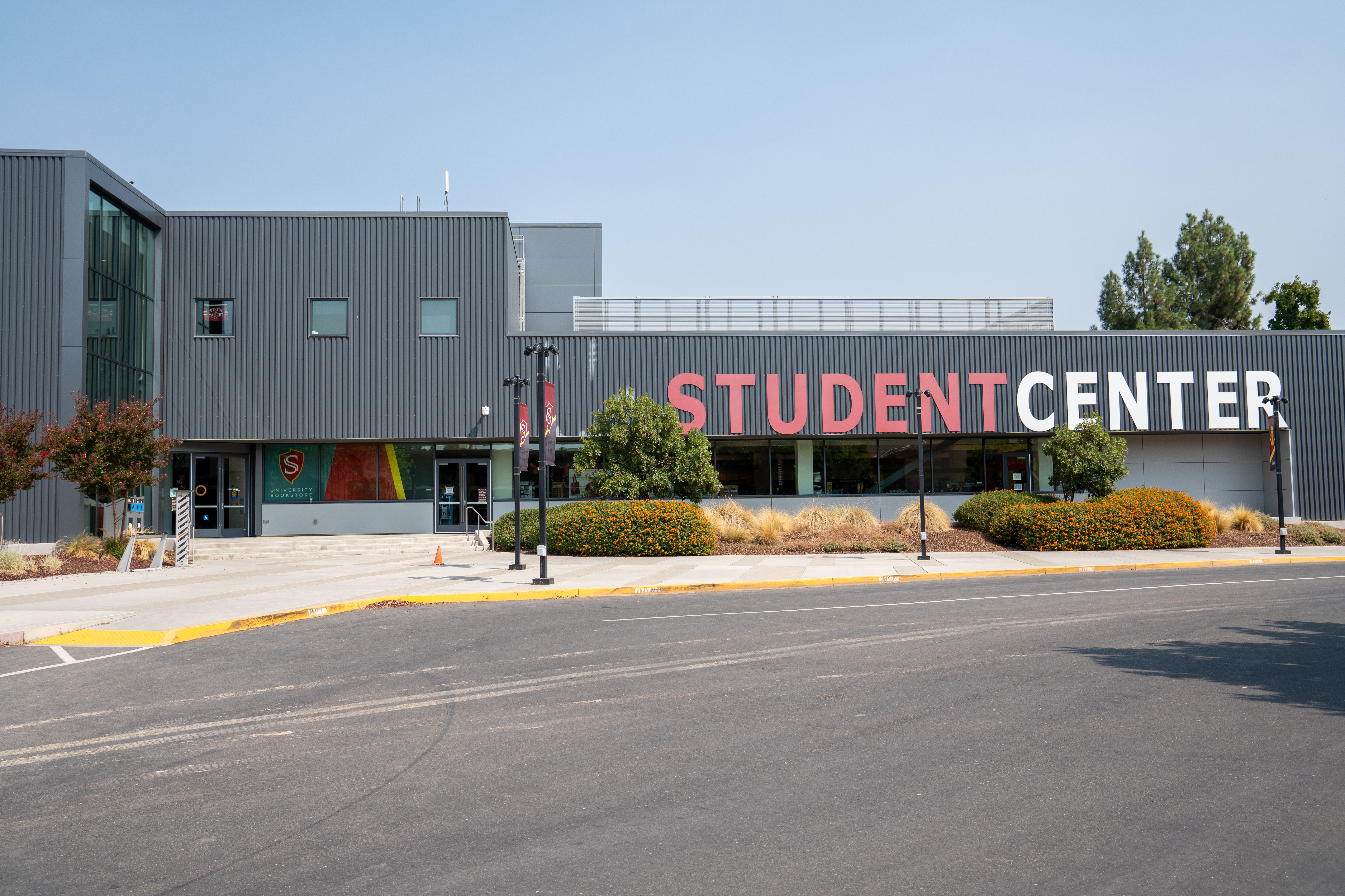 Exterior view of the Stanislaus State Student Center and bookstore entrance along Shield Way