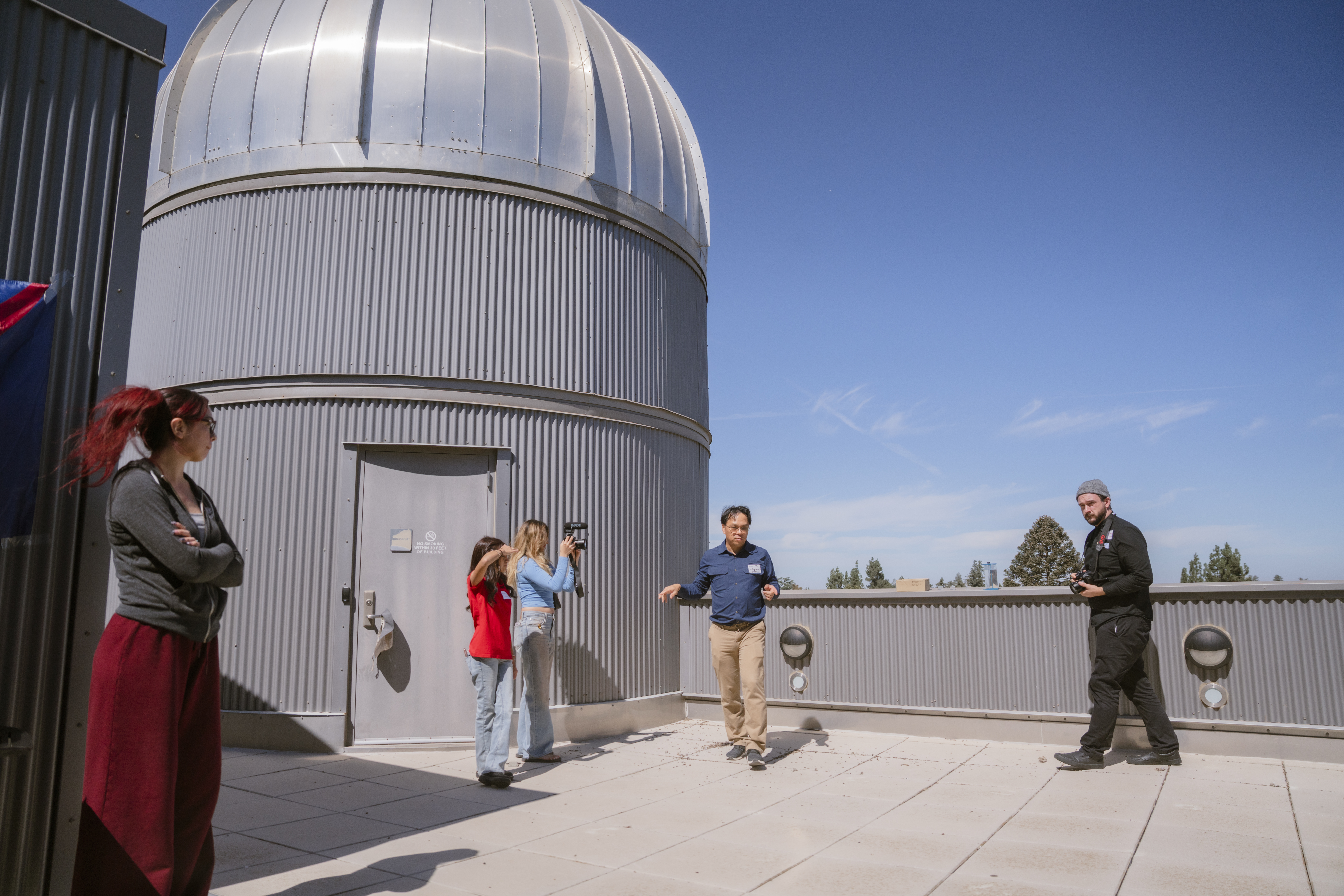 Students conduct an interview on the roof of Naraghi Hall.