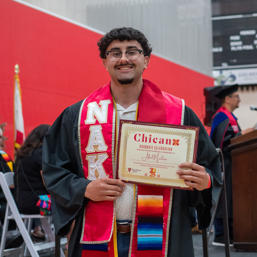 Graduate posed with Chicanx Celebration degree.