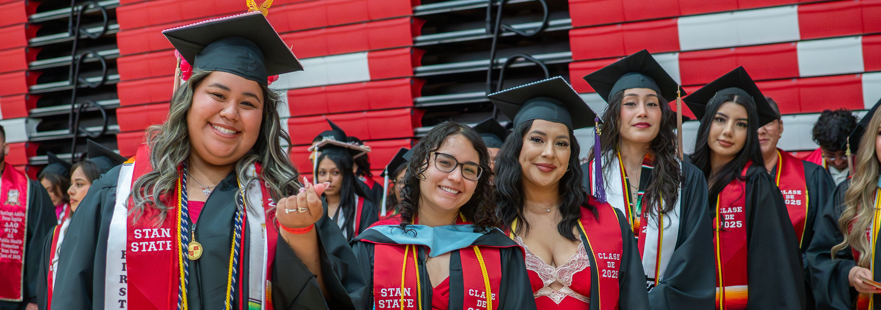 Group of five graduates posed together for a photo.