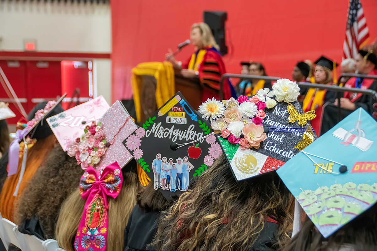 Graduates wear decorated caps featuring flowers, family photos, cultural symbols and graduation messages during Stanislaus State’s Chicanx/Latine Graduation Celebration.