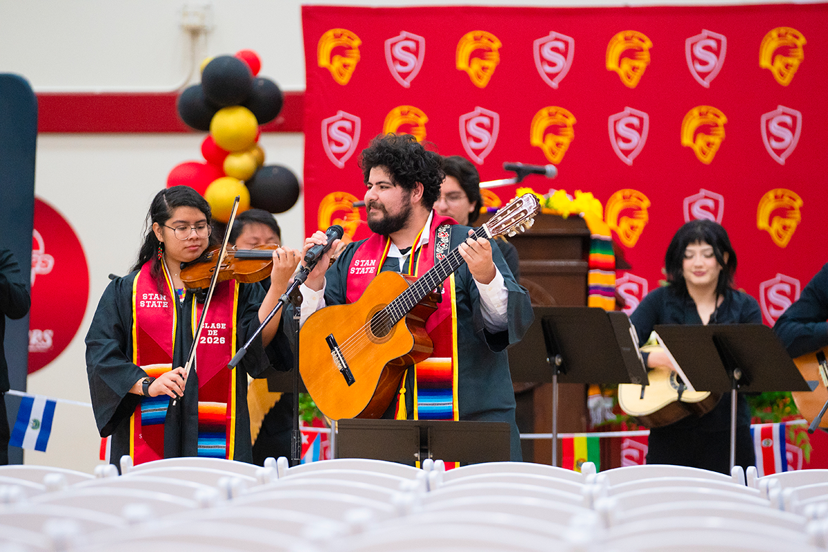 Stanislaus State graduates perform with violin and guitar during the Chicanx/Latine Graduation Celebration.