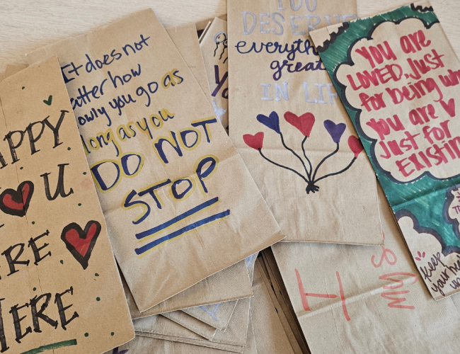 Various paper bags with encouragement quotes written on them.