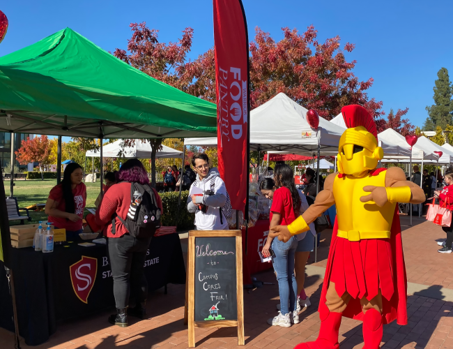 Titus stands near a booth in the quad at Stan State.