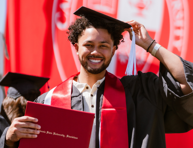 A graduate holding their degree