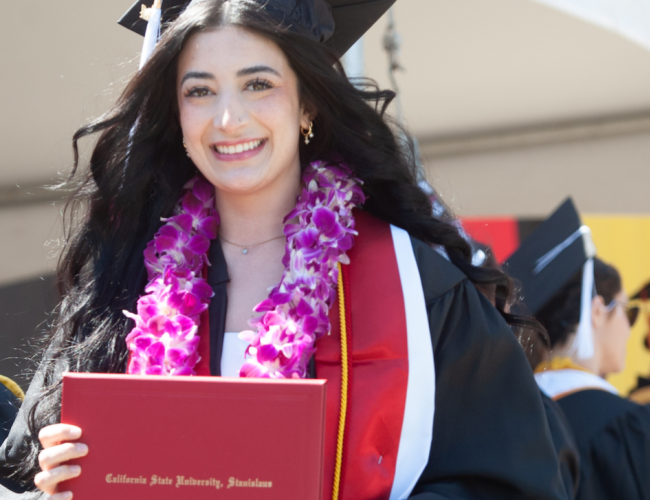 A graduate holding their degree