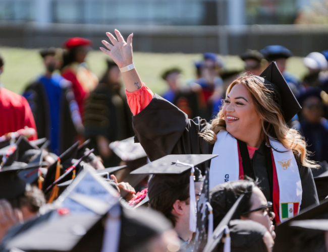 A graduate waving