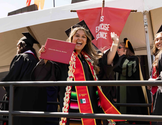 A graduate holding their degree
