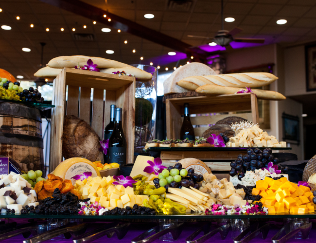 A buffet table featuring an array of cheeses and fruits.
