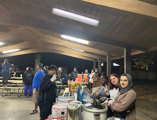 Stan State fellows serving food at a camping event partnered with Chico State