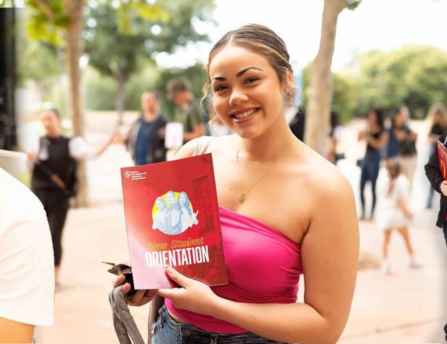 Student holding New Student Orientation program