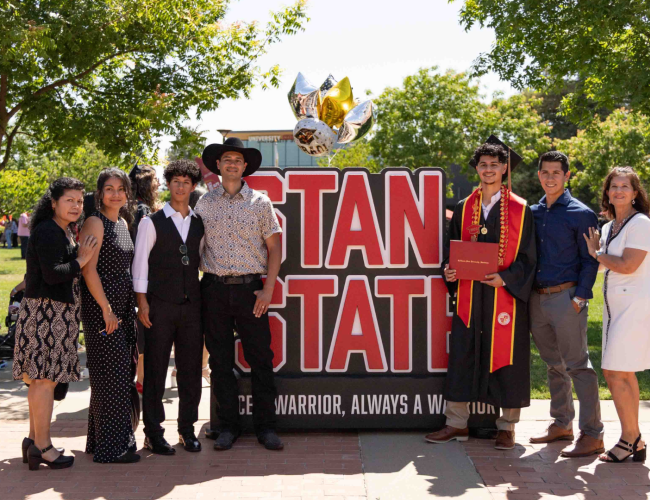 Graduate in a group photo with his family.