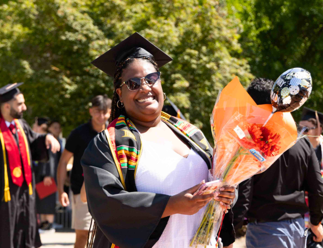 Graduates are seen walking in the quad for lineup