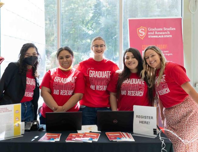 Staff from the Graduate Studies gathered for a group photo at a check in desk