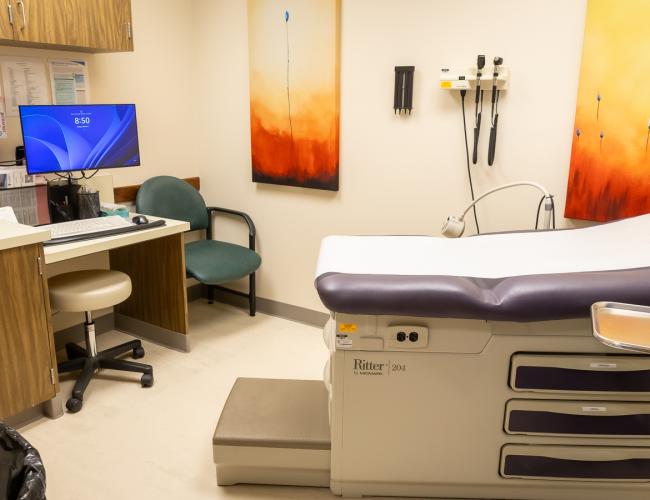 Medical exam room with examination table and computer