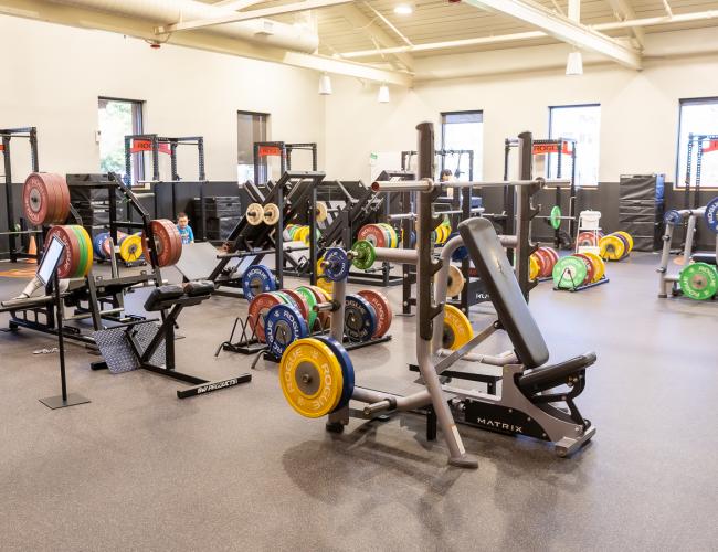Weight room with barbells and squat racks