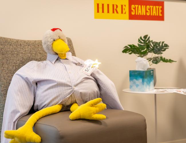 Hire Stan State chicken sitting in chair