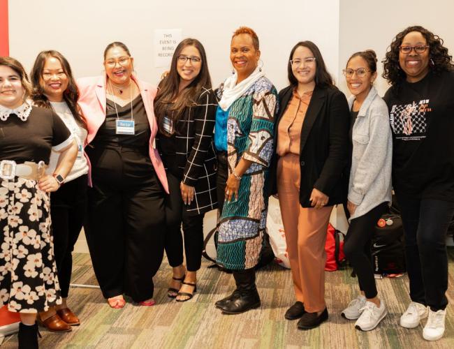 Participants from a grad studies event are seen in a group photo