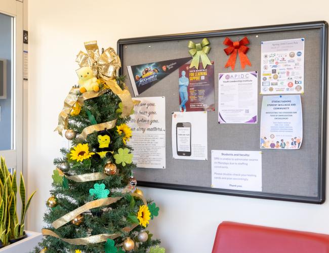 Decorated tree and bulletin board with event flyers