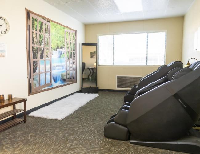 Relaxation room with massage chairs and nature mural