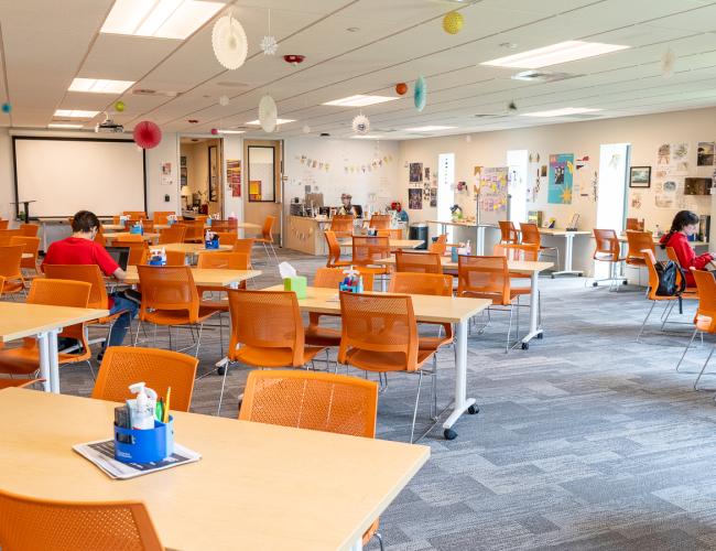 Learning commons open study area with orange chairs and projection screen