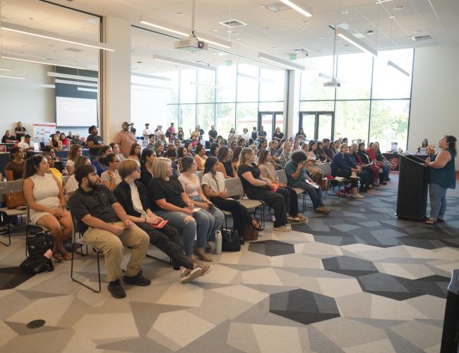 Crowd of graduate students seen in a conference room