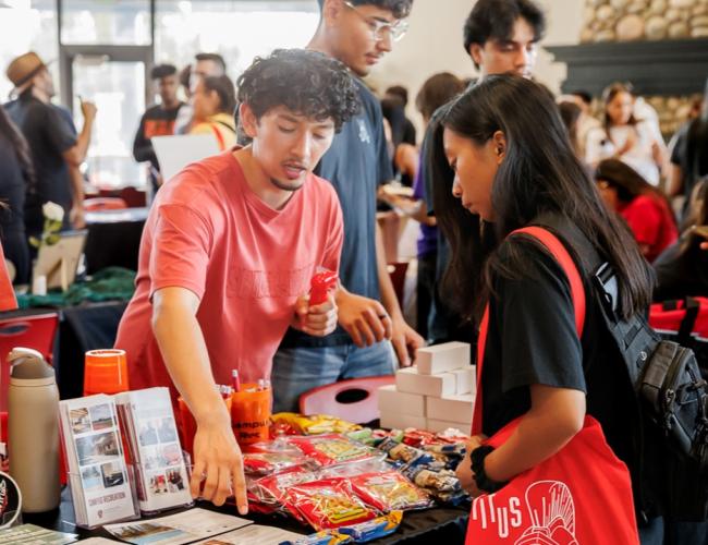 Student is seen at an NSO table booth